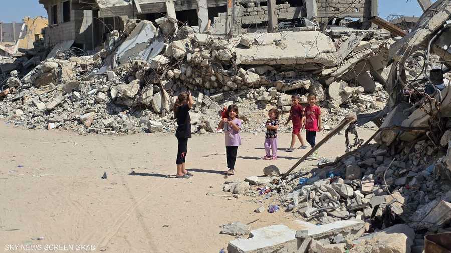 أطفال يمرون قرب مبان دمرتها الحرب