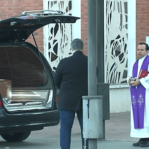 مراسم جنازة تقام أمام السيارة التي تحمل جثمان الميت