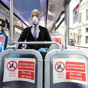 رجل يضع كمامة للوقاية من فيروس كورونا في حافلة بفرنسا.