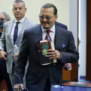 جوني ديب حاملا دفتر الرسم الخاص به